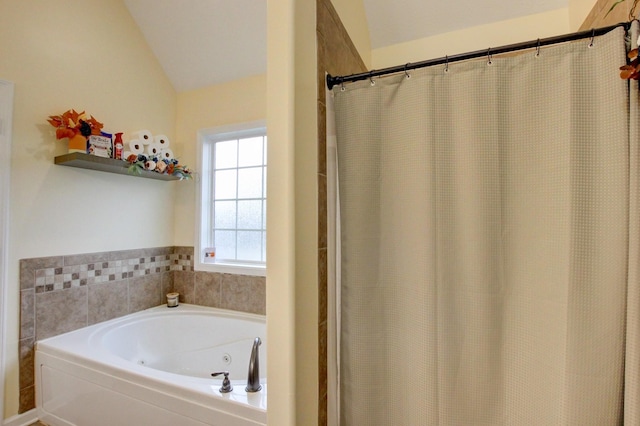 full bathroom featuring a jetted tub and lofted ceiling