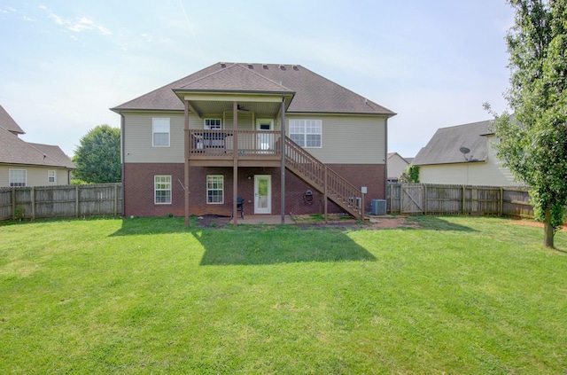 rear view of house featuring a fenced backyard, stairs, a lawn, and central AC