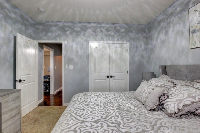 carpeted bedroom featuring baseboards and a closet