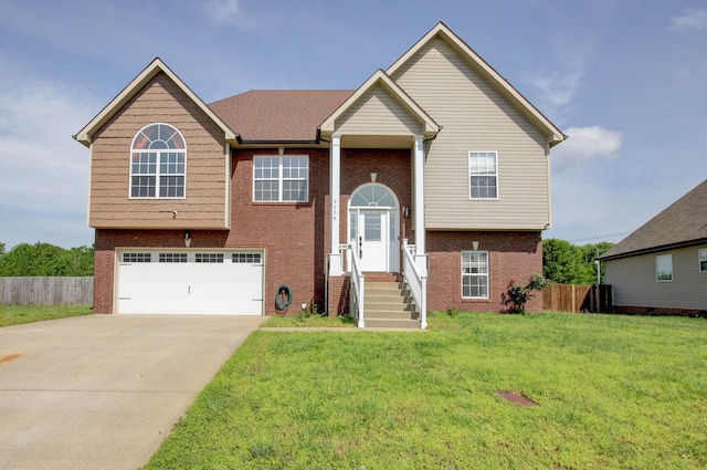 split foyer home featuring brick siding, an attached garage, fence, and a front yard