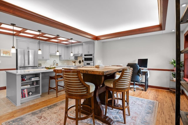 dining room with crown molding, recessed lighting, baseboards, and light wood-style flooring