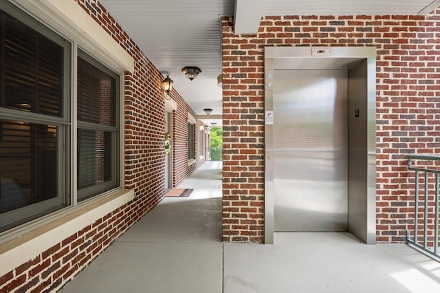 entrance to property with elevator and brick siding