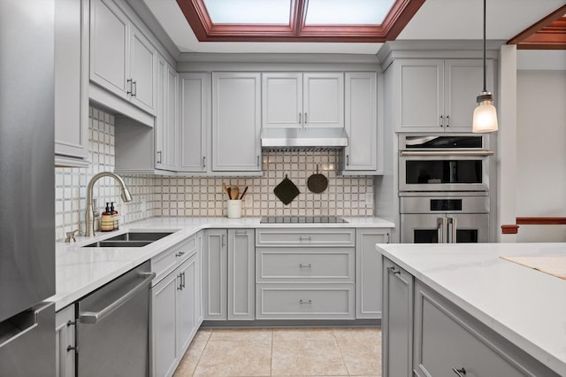 kitchen with stainless steel appliances, gray cabinetry, and a sink