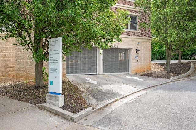 exterior space with stone siding, concrete driveway, and brick siding