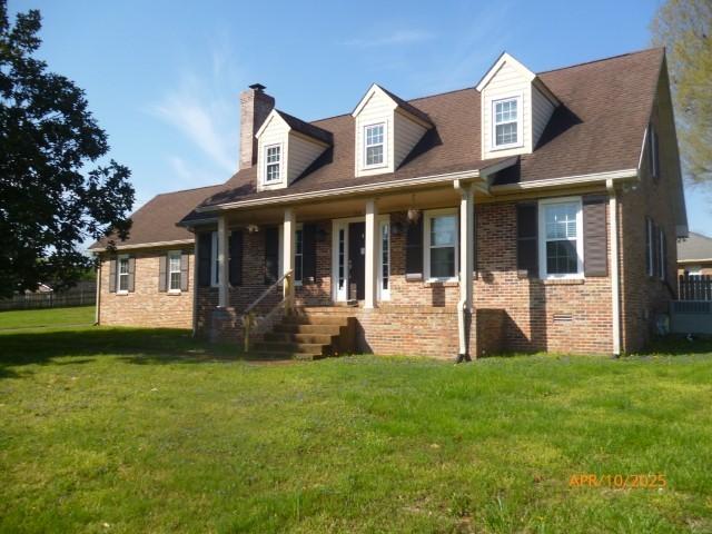 1314 Jewell Dr, Columbia, TN 38401 - rear view of house featuring covered porch, brick siding, a yard, and a chimney
