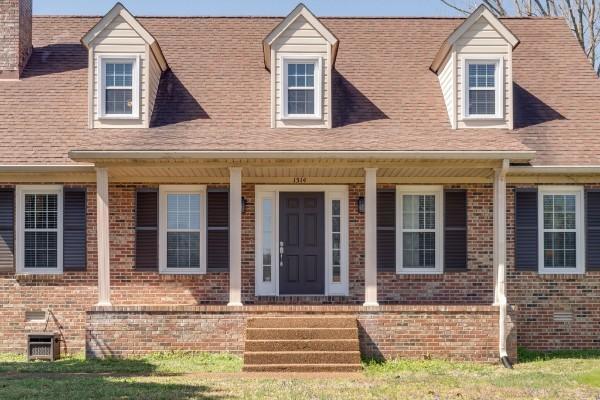 1314 Jewell Dr, Columbia, TN 38401 - cape cod home with brick siding, roof with shingles, and covered porch