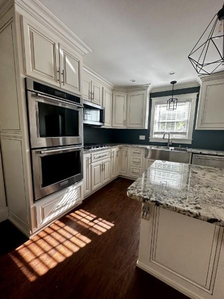1314 Jewell Dr, Columbia, TN 38401 - kitchen with light stone countertops, dark wood-style floors, a sink, appliances with stainless steel finishes, and decorative light fixtures