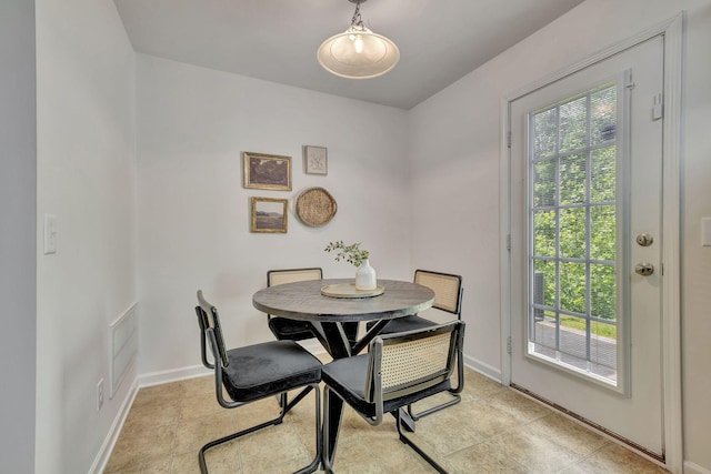 dining space featuring baseboards and light tile patterned floors