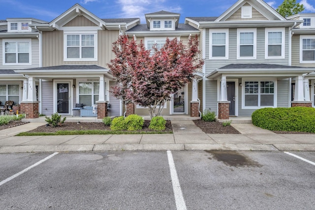 multi unit property featuring covered porch, board and batten siding, and uncovered parking