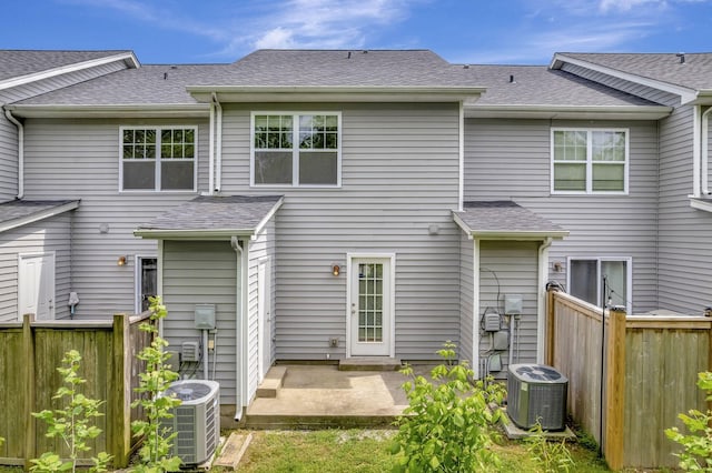 back of house with central air condition unit, fence, a patio, and a shingled roof