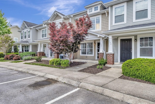 townhome / multi-family property with a porch and uncovered parking
