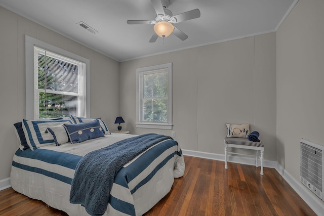 bedroom featuring visible vents, baseboards, crown molding, and wood finished floors