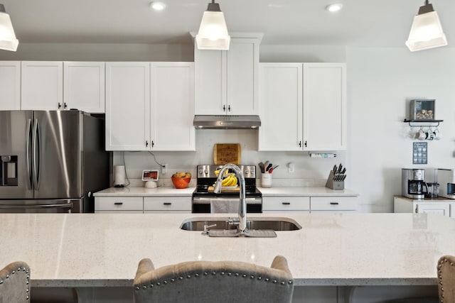 907 Caywood Rd, Smyrna, TN 37167 - kitchen with under cabinet range hood, hanging light fixtures, white cabinetry, and appliances with stainless steel finishes