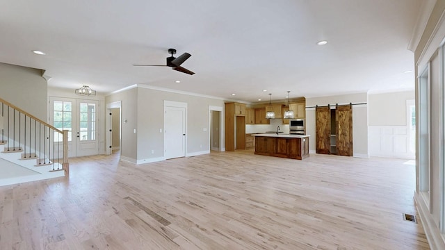 1150 Parsons Rd, Christiana, TN 37037 - unfurnished living room with light wood-type flooring, a barn door, stairway, a sink, and ornamental molding