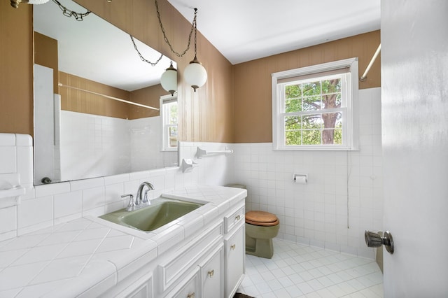 bathroom featuring toilet, walk in shower, a wealth of natural light, and tile walls