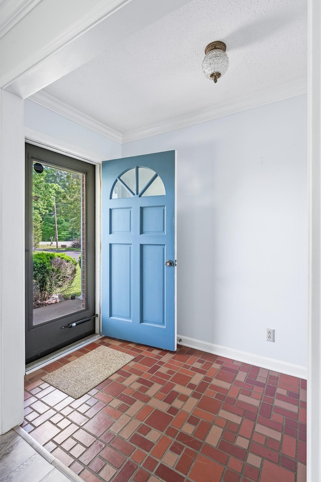 foyer featuring crown molding, baseboards, and a textured ceiling