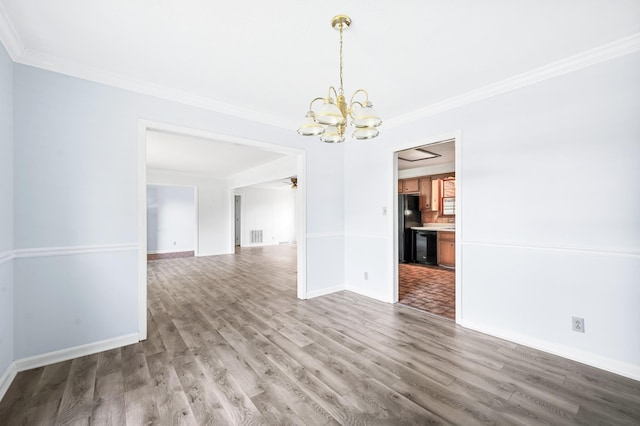 unfurnished dining area featuring baseboards, ornamental molding, wood finished floors, and a chandelier