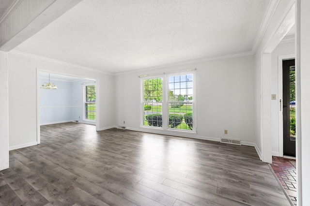 spare room with plenty of natural light, crown molding, and a notable chandelier