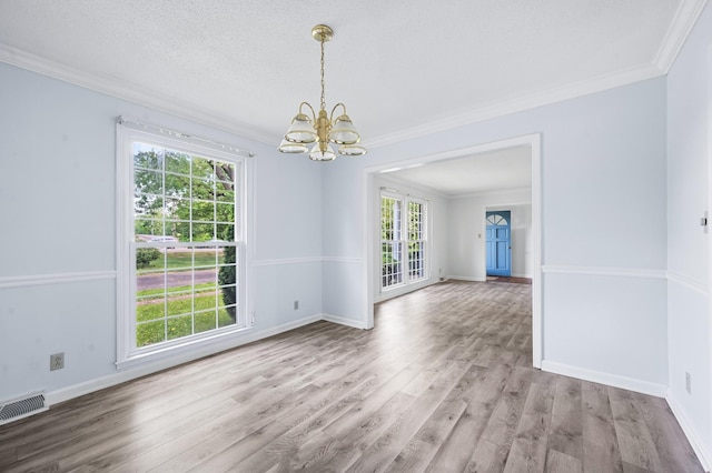 interior space featuring visible vents, ornamental molding, wood finished floors, and a chandelier