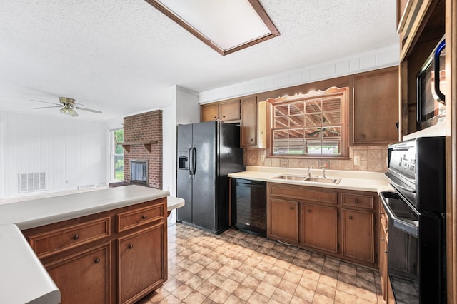 kitchen with visible vents, a sink, black appliances, and light countertops