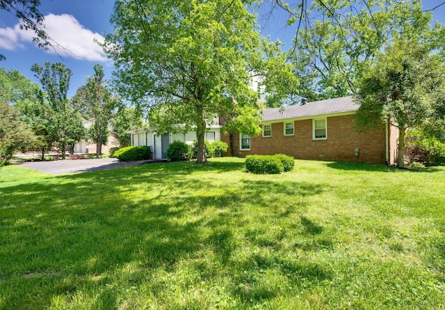 view of yard featuring driveway and a garage