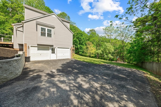 view of side of home featuring an attached garage and driveway