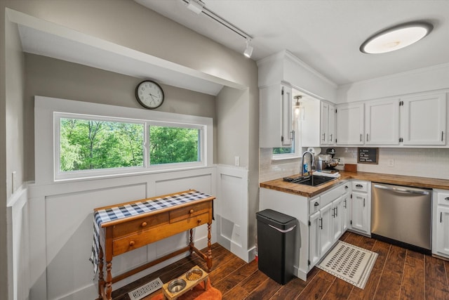 kitchen with a sink, wood counters, stainless steel dishwasher, and white cabinetry
