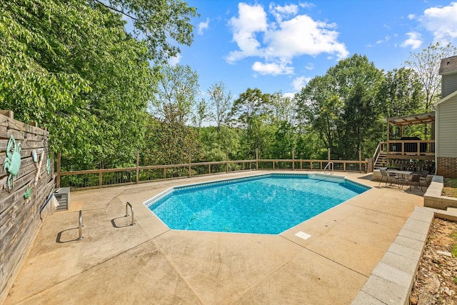 view of pool featuring a fenced in pool, a patio, and a wooden deck