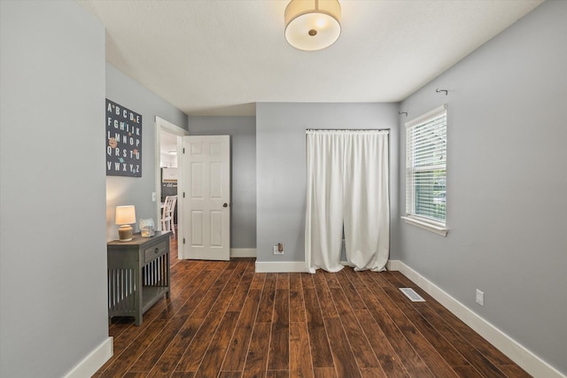 interior space featuring baseboards, visible vents, and wood finished floors