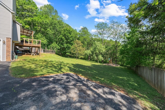 view of yard featuring a patio, a fenced backyard, a wooden deck, and stairway