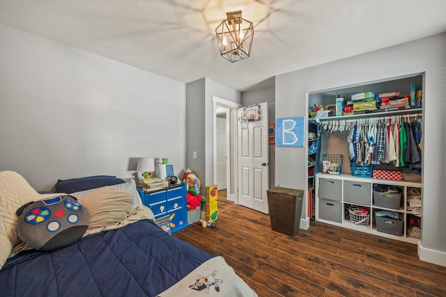 bedroom with a closet, wood finished floors, and a chandelier