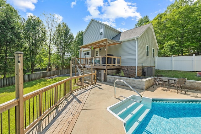 view of pool featuring a lawn, a wooden deck, a fenced backyard, a patio, and stairs