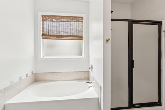 full bath featuring a garden tub and a shower stall