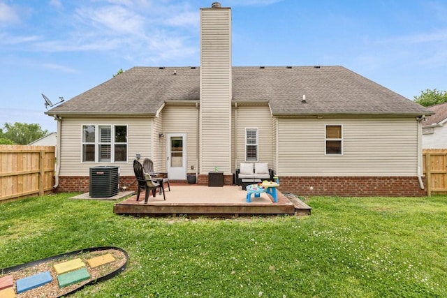 back of property with a chimney, central AC unit, a wooden deck, a fenced backyard, and a yard