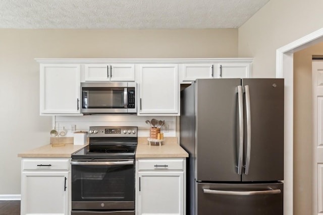 kitchen with light countertops, stainless steel appliances, white cabinets, and a textured ceiling