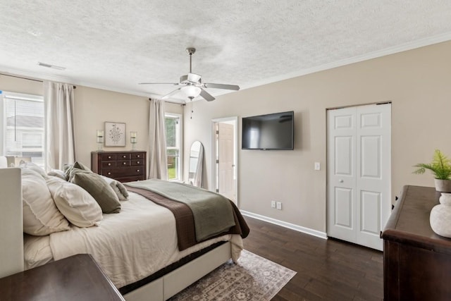 bedroom with baseboards, a textured ceiling, dark wood-style flooring, and visible vents