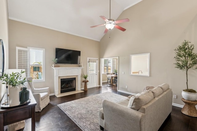 living room featuring a high end fireplace, baseboards, a ceiling fan, and dark wood-style flooring