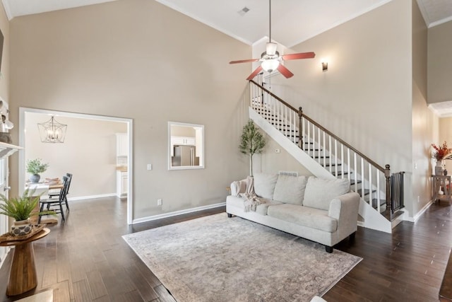 living room featuring high vaulted ceiling, ceiling fan with notable chandelier, stairs, baseboards, and dark wood-style floors