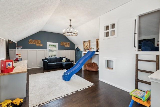 playroom with a chandelier, vaulted ceiling, a textured ceiling, and wood finished floors