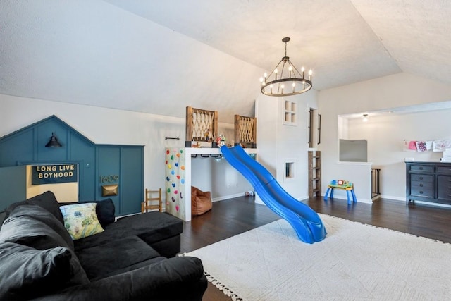 interior space with baseboards, a notable chandelier, wood finished floors, and vaulted ceiling