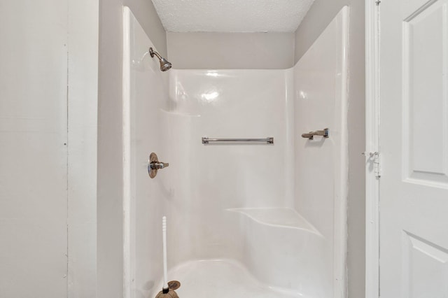 bathroom with a textured ceiling and walk in shower