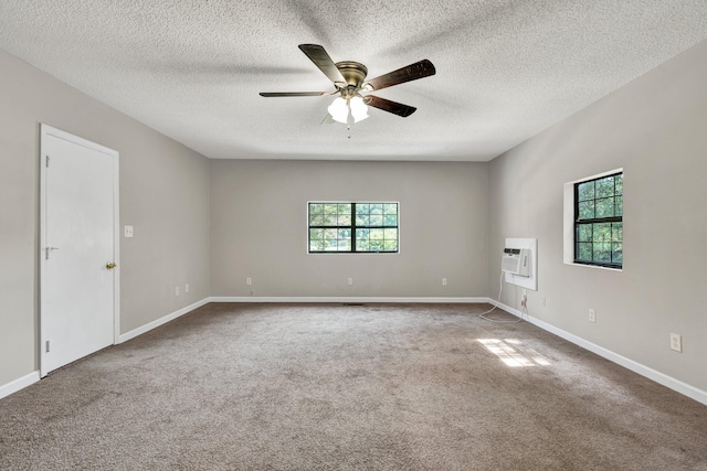 carpeted empty room featuring baseboards, a ceiling fan, and a textured ceiling