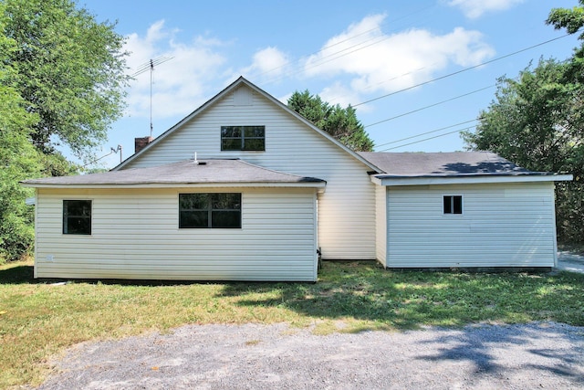 back of house with roof with shingles