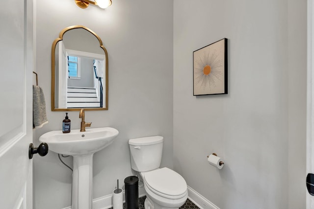 half bathroom with toilet and baseboards