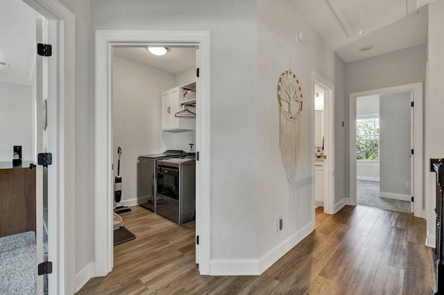 hallway with baseboards, attic access, independent washer and dryer, and wood finished floors