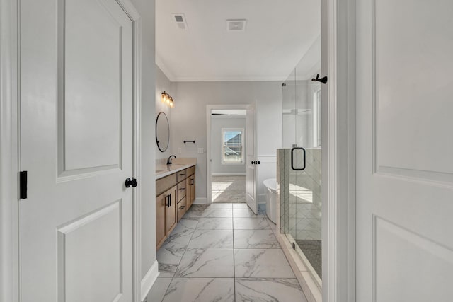 full bathroom with double vanity, ornamental molding, marble finish floor, a freestanding tub, and a shower stall