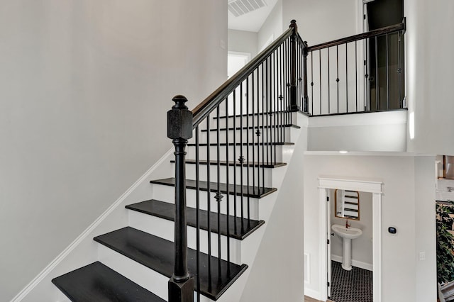 staircase with baseboards and visible vents