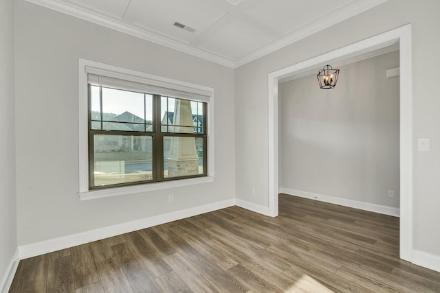 spare room featuring ornamental molding, dark wood-type flooring, a chandelier, and visible vents