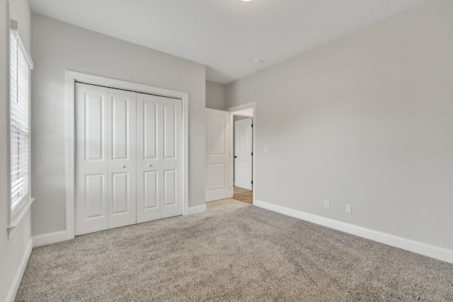 unfurnished bedroom featuring baseboards, carpet, and multiple windows