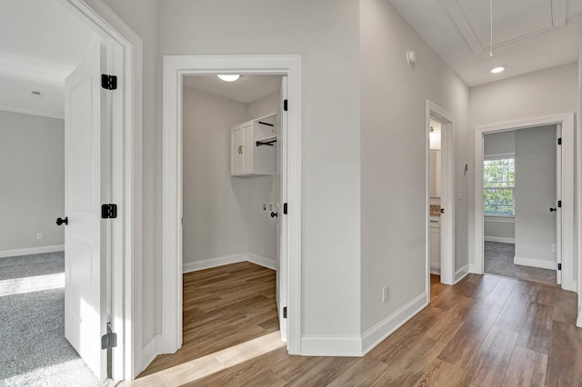 hall with baseboards, attic access, recessed lighting, and wood finished floors